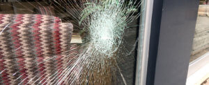 A broken glass window in a storefront